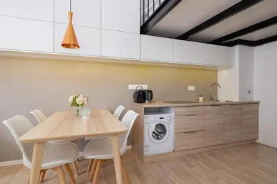 a kitchen with a table and a washing machine at Studio z Klimatyzacją na Krakowskim Kazimierzu by Noclegi Renters in Kraków