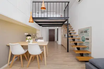 a dining room with a table and chairs and a staircase at Studio z Klimatyzacją na Krakowskim Kazimierzu by Noclegi Renters in Kraków
