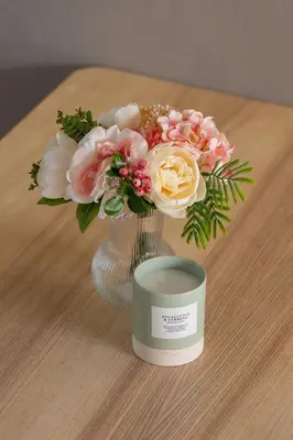 a vase with flowers and a candle on a table at Studio z Klimatyzacją na Krakowskim Kazimierzu by Noclegi Renters in Kraków