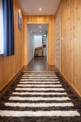 a hallway with wood paneling and a hallway with a rug at Dom u Teresy in Harkabuz