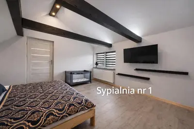a bedroom with a bed and a flat screen tv at Dom u Teresy in Harkabuz