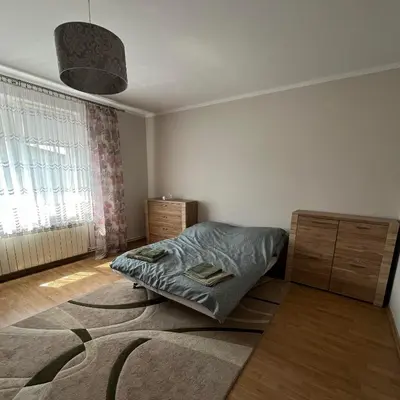 a bedroom with a bed and a large rug at Pogodny Dom in Włosienica