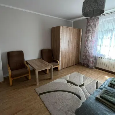 a living room with two chairs and a table and a rug at Pogodny Dom in Włosienica
