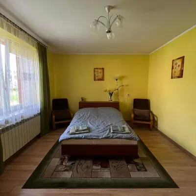 a bedroom with a bed and two chairs in it at Pogodny Dom in Włosienica