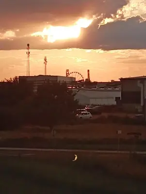 a sunset over a parking lot with a roller coaster at Blisko Energylandii in Zator
