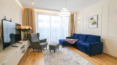 a living room with a blue couch and a tv at Luxury apartment Free parking - by Hosty in Kraków