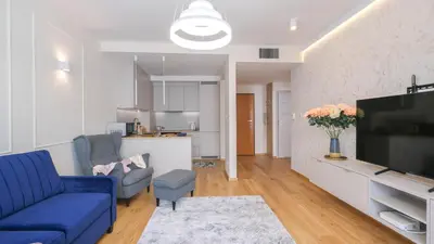 a living room with a blue couch and a tv at Luxury apartment Free parking - by Hosty in Kraków