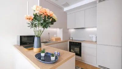 a kitchen with a vase of flowers on a counter at Luxury apartment Free parking - by Hosty in Kraków