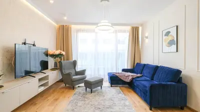 a living room with a blue couch and a tv at Luxury apartment Free parking - by Hosty in Kraków