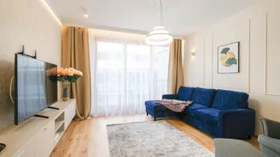 a living room with a blue couch and a tv at Luxury apartment Free parking - by Hosty in Kraków