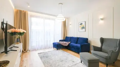 a living room with a blue couch and two chairs at Luxury apartment Free parking - by Hosty in Kraków