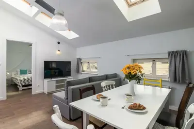 a dining room and living room with a white table and chairs at 2-Bedroom Apartment - Sarego 16 in Kraków