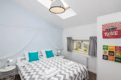 a white bedroom with a bed with blue and white pillows at 2-Bedroom Apartment - Sarego 16 in Kraków