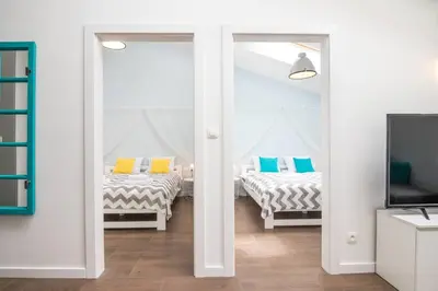 a living room with two beds and a tv at 2-Bedroom Apartment - Sarego 16 in Kraków