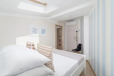a white bedroom with a white bed and a chair at 3-Bedroom apartment in the centre - Old Town in Kraków
