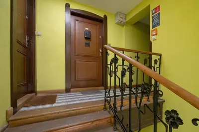 a hallway with a wooden door and a staircase at 3-Bedroom apartment in the centre - Old Town in Kraków