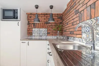 a kitchen with a sink and a brick wall at 3-Bedroom apartment in the centre - Old Town in Kraków