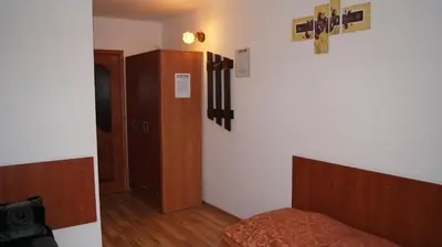 a bedroom with a bed and a wooden cabinet at Willa Pod Dębami - SALA ZABAW - Małpi Gaj - blisko centrum in Rabka
