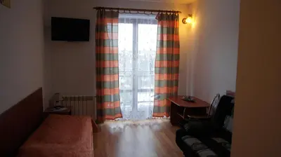 a bedroom with a bed and a window with curtains at Willa Pod Dębami - SALA ZABAW - Małpi Gaj - blisko centrum in Rabka