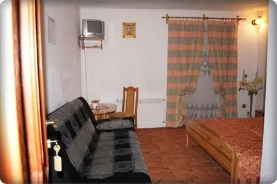 a bedroom with a bed and a couch and a tv at Willa Pod Dębami - SALA ZABAW - Małpi Gaj - blisko centrum in Rabka