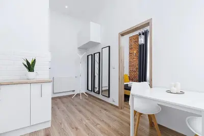 a kitchen and living room with white walls and wooden floors at Two-bedroom apartment - Old Town in Kraków