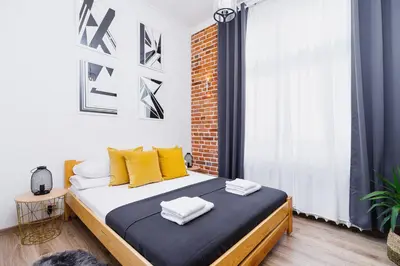 a bedroom with a bed with yellow pillows on it at Two-bedroom apartment - Old Town in Kraków
