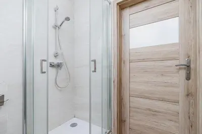 a shower with a glass door in a bathroom at Two-bedroom apartment - Old Town in Kraków