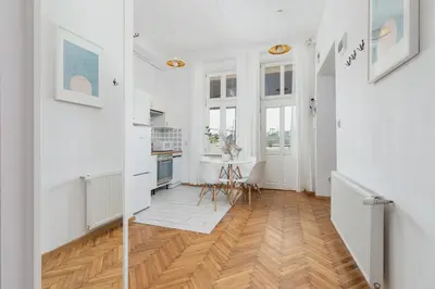 a kitchen with white walls and a wooden floor at Entire apartment in Kraków, Poland in Kraków