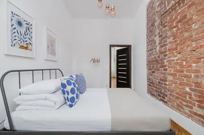 a bedroom with a bed with a brick wall at Entire apartment in Kraków, Poland in Kraków
