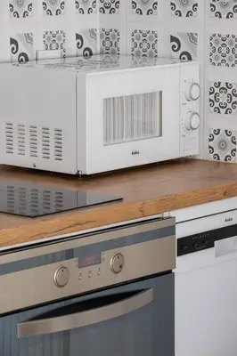 a white microwave oven sitting on top of a kitchen counter at Entire apartment in Kraków, Poland in Kraków