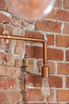 a light fixture hanging from a brick wall at Entire apartment in Kraków, Poland in Kraków