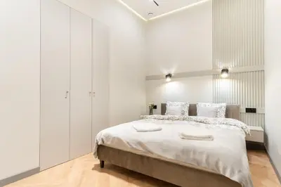 a white bedroom with a large bed with white walls at Charm & Comfort Renovated Gem in Old Town Sarego apt B in Kraków