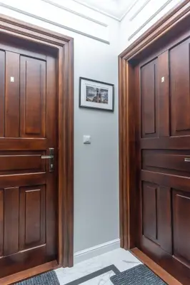 a pair of wooden doors in a hallway at Charm & Comfort Renovated Gem in Old Town Sarego apt B in Kraków