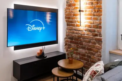 a living room with a flat screen tv on a brick wall at Charm & Comfort Renovated Gem in Old Town Sarego apt B in Kraków