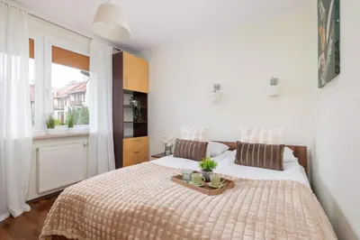a bedroom with a bed with a tray on it at Cracow Verdant Apartment with Parking by Noclegi Renters in Kraków
