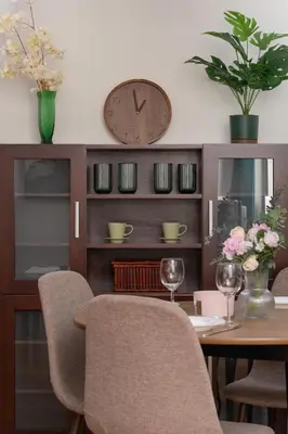 a dining room with a table and a clock on the wall at Cracow Verdant Apartment with Parking by Noclegi Renters in Kraków
