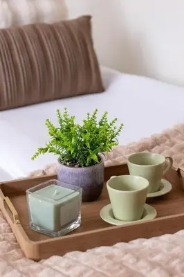 a tray with two cups and a plant on a bed at Cracow Verdant Apartment with Parking by Noclegi Renters in Kraków