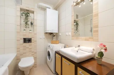a bathroom with a sink and a washing machine at Cracow Verdant Apartment with Parking by Noclegi Renters in Kraków