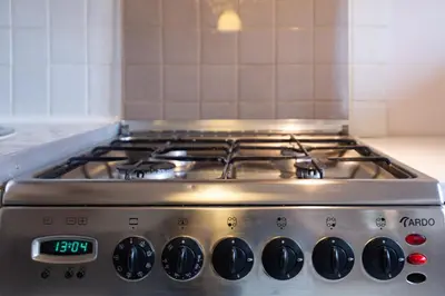 a kitchen with white cabinets and a stove and a sink at Sky's the limit! Spacey loft in Kraków