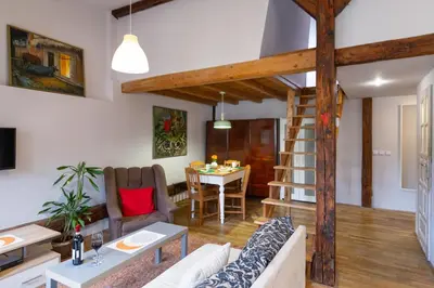 a kitchen with white cabinets and a stove top oven at Sky's the limit! Spacey loft in Kraków