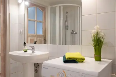 a white bathroom with a sink and a mirror at Sky's the limit! Spacey loft in Kraków