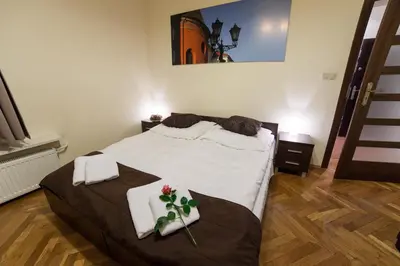 a bedroom with a bed with flowers on it at Place 4 You Apartments in Kraków
