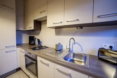 a kitchen with a sink and a microwave at Place 4 You Apartments in Kraków