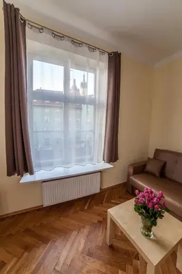 a living room with a window with a couch and a table at Place 4 You Apartments in Kraków