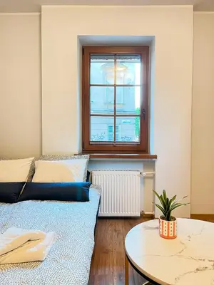 a room with a bed and a table and a window at Large Apartment 2 bedrooms and living room, Kazimierz District in Kraków