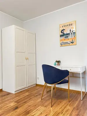 a blue chair sitting next to a desk in a room at Large Apartment 2 bedrooms and living room, Kazimierz District in Kraków