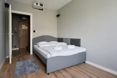 a bedroom with a bed with white sheets at RentPlanet - Apartament Kasztelańska in Kraków