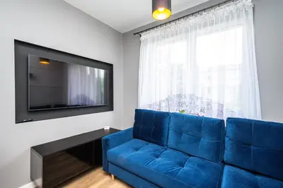 a blue couch in a living room with a tv at RentPlanet - Apartament Kasztelańska in Kraków