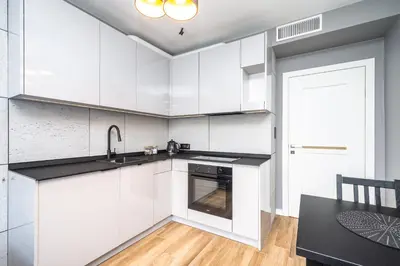 a white kitchen with a sink and a stove at RentPlanet - Apartament Kasztelańska in Kraków