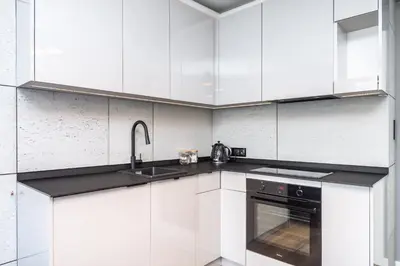 a white kitchen with a sink and a stove at RentPlanet - Apartament Kasztelańska in Kraków